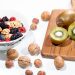 A vibrant bowl of mixed berries, walnuts, and kiwi on a cutting board. Perfect for a healthy breakfast.
